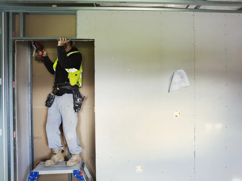 Operario instalando tabiques de pladur en una vivienda